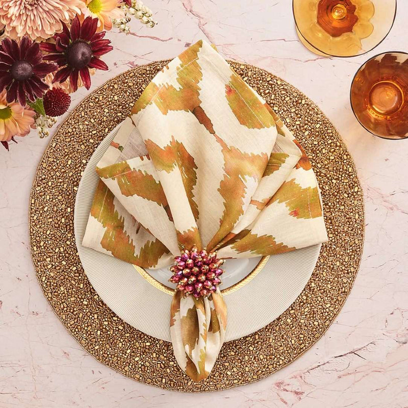 Rust orange Watercolor Ikat napkin by Kim Seybert, styled on autumn table setting, top view.