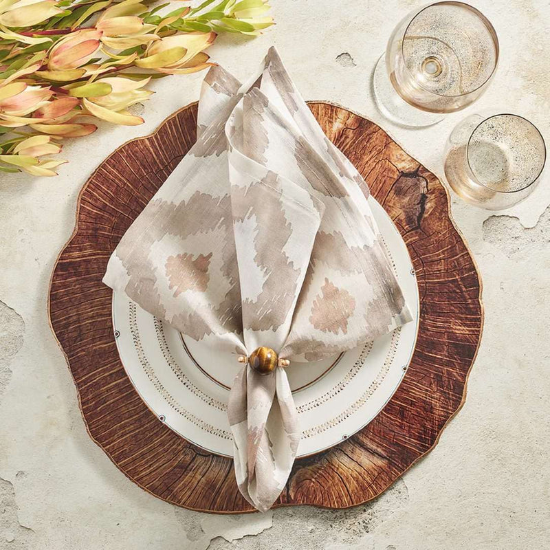 Watercolor Ikat napkin in taupe by Kim Seybert styled on a wood pattern placemat