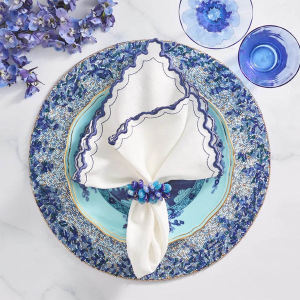 Top view of Arches napkin styled with beaded navy blue napkin ring and placemat, by Amiramour
