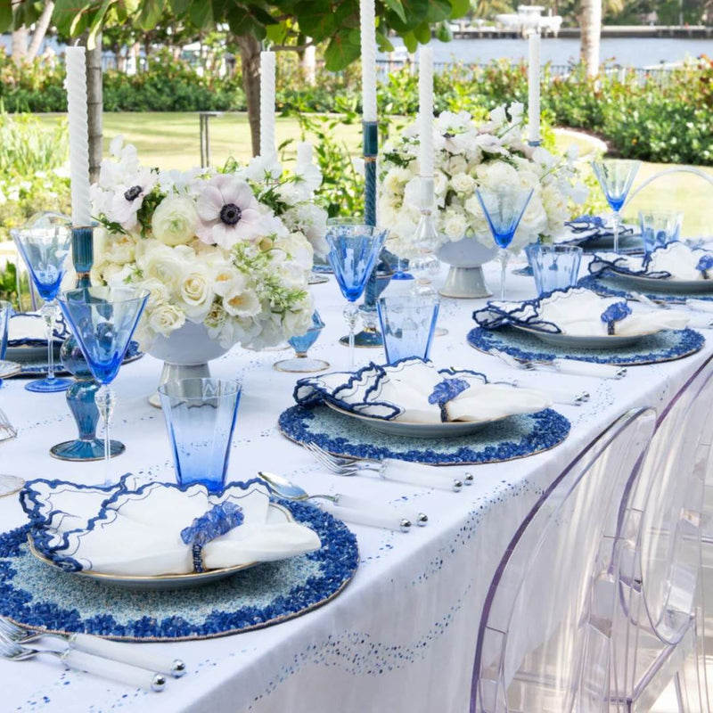 Side view of daytime table setting with Arches napkin, crystal napkin rings, and beaded placemats sold by Amiramour