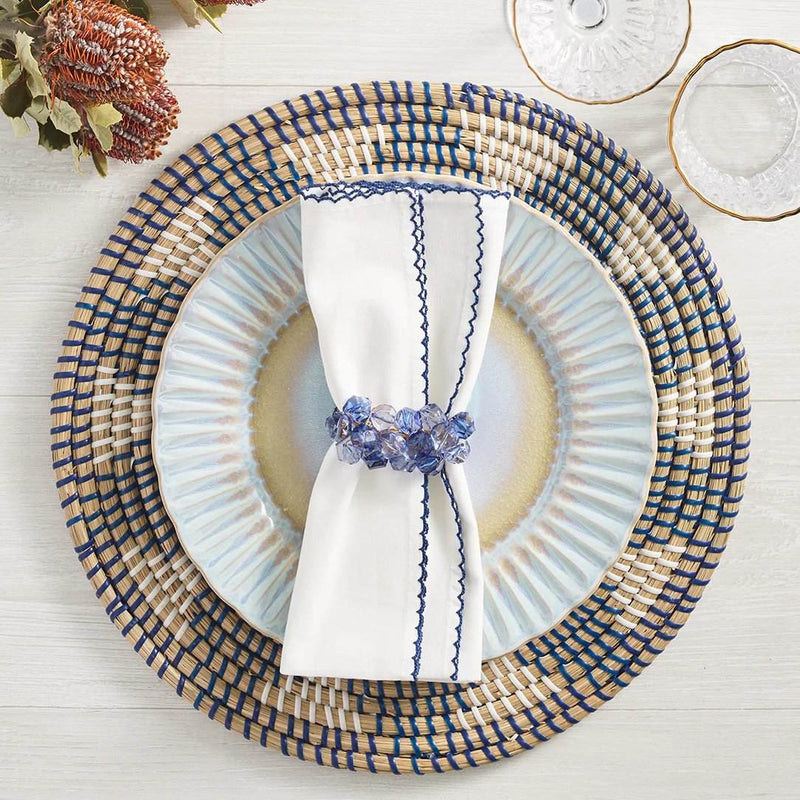 Casbah napkin in white and blue by Kim Seybert styled with blue beaded napkin ring