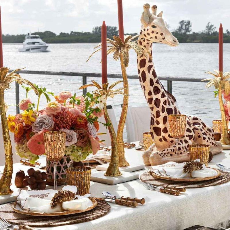 Royal Palm napkin styled with beaded placemat and soft neutrals on a refined tropical table