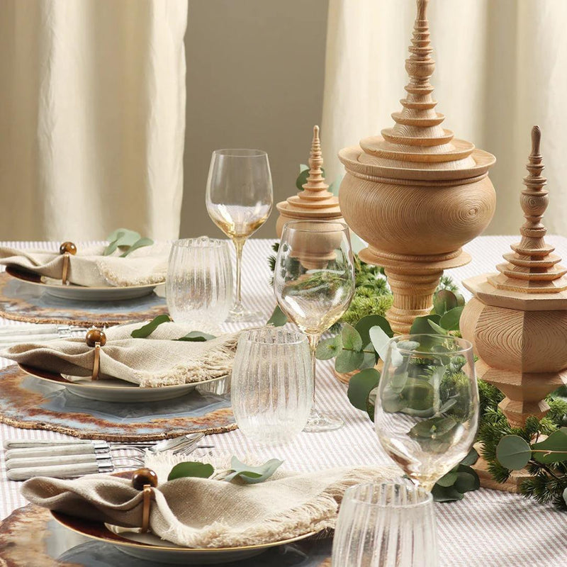 Brown linen napkin with fringe and an organic, textured look by Kim Seybert styled on organic table scape