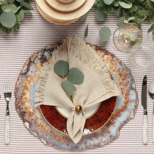 Brown linen napkin with fringe and an organic, textured look by Kim Seybert styled top view