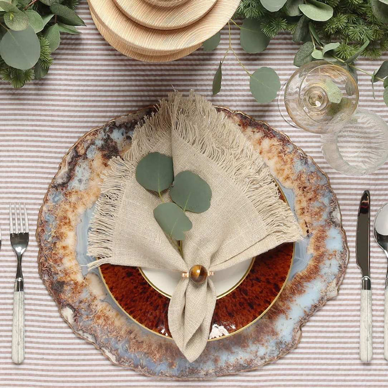 Brown linen napkin with fringe and an organic, textured look by Kim Seybert styled top view