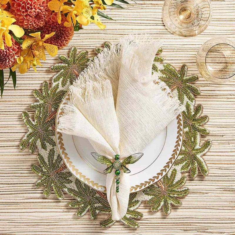 Fringe napkin styled on a tropical palm tree motifs table setting, top view 