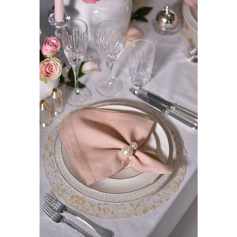 Blush pink linen napkin by Alexandre Turpault styled on elegant table setting with roses.