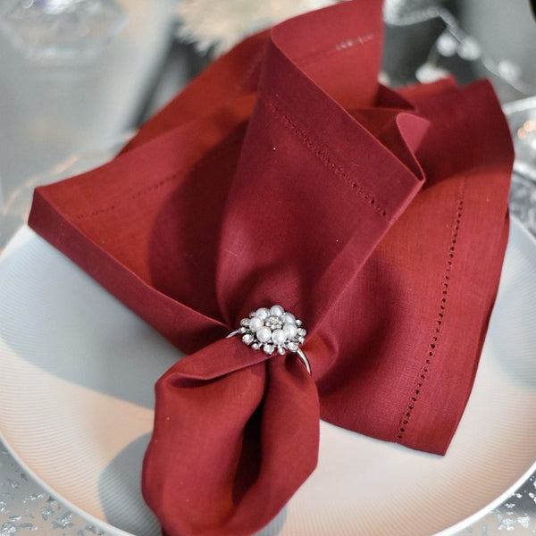 Red  linen napkin with stain-resistant Teflon coating on white plate, sold at Amiramour.