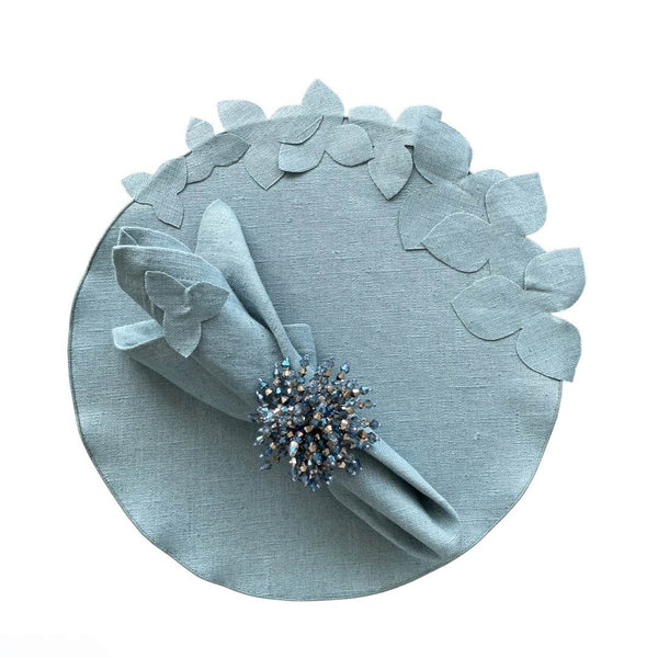Sky blue linen napkin with hydrangea appliqué by Giardino Segreto, styled on round hydrangea placemat.