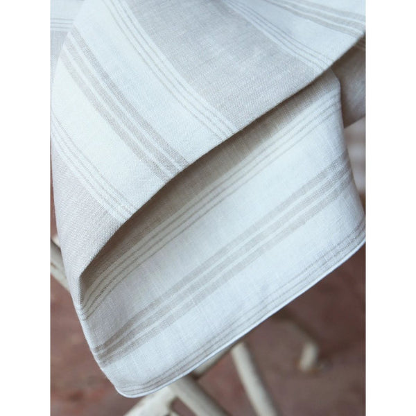 Close-up of Riva linen napkin showing stripe pattern and tonal piped edge