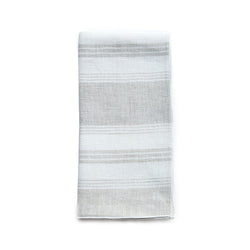 Folded Riva beige and white striped linen napkin with piped edge on white background by Amiramour