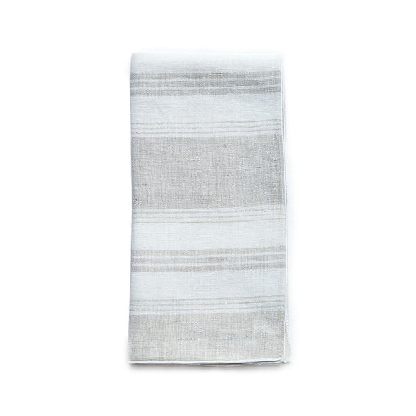 Folded Riva beige and white striped linen napkin with piped edge on white background by Amiramour