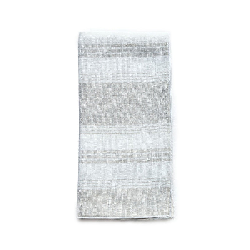 Folded Riva beige and white striped linen napkin with piped edge on white background by Amiramour