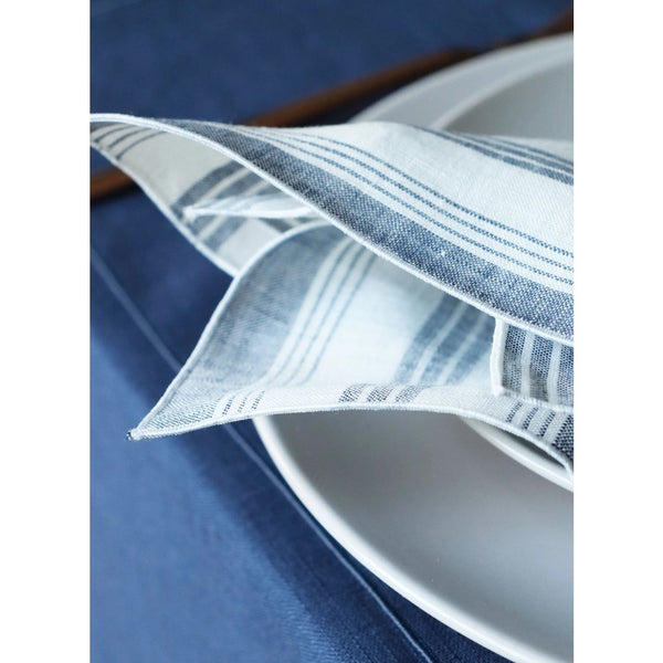 Close-up of the piped edge Riva blue and white striped linen napkin by Giardino Segreto