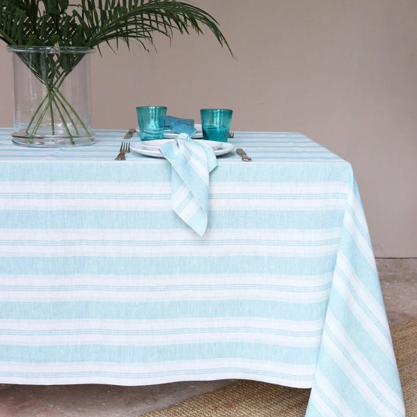 Riva turquoise and white striped linen napkin with piped edge on Riva turquoise and white striped tablecloth