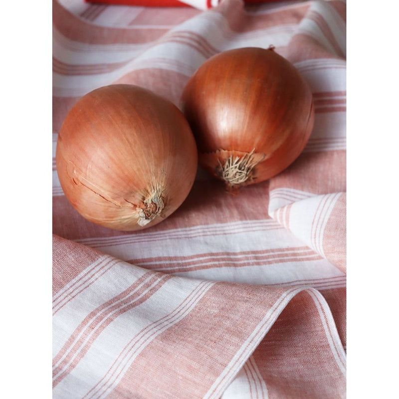 Linen napkin with coral and white irregular stripes close-up on the fabric, sold at Amiramour.