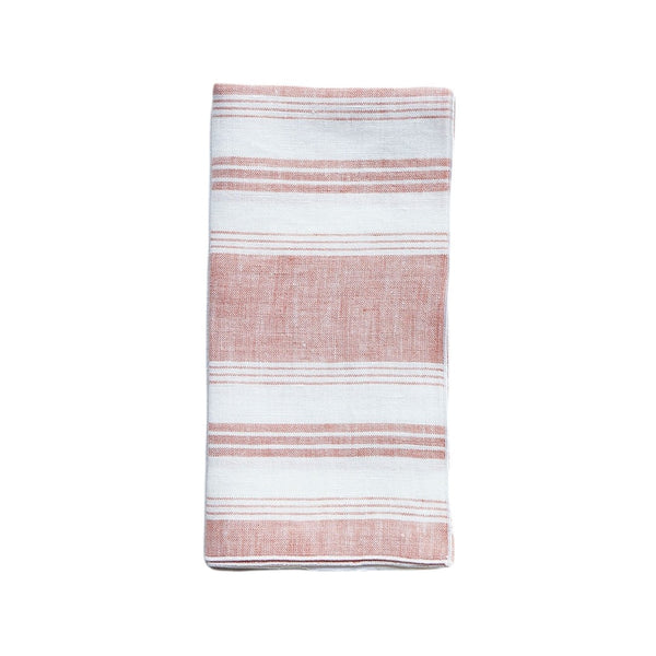 Linen napkin with coral and white irregular stripes by Giardino Segreto on white background.
