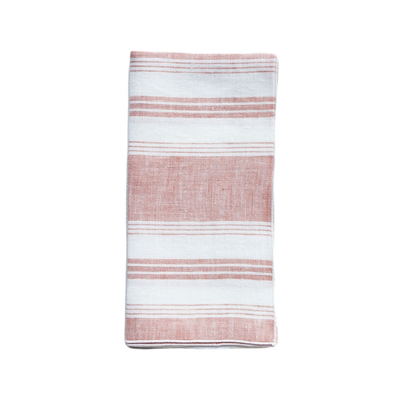Linen napkin with coral and white irregular stripes by Giardino Segreto on white background.