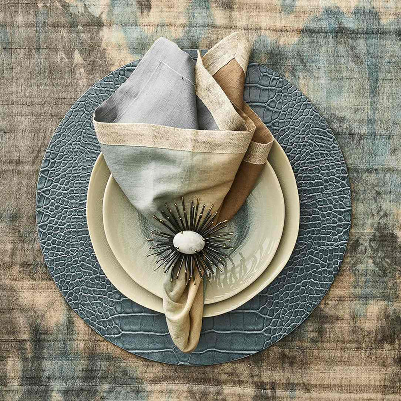 Beige, taupe, and grey linen napkin with metallic foil detail styled with modern black napkin ring.