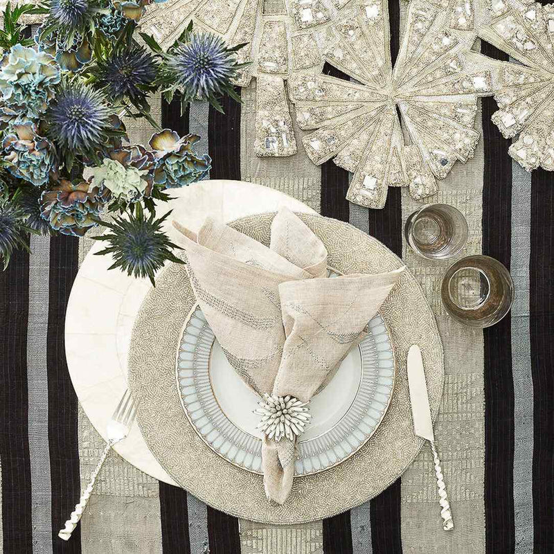 Styled variegated linen napkin on sparkly silver placemat, top view, sold at Amiramour