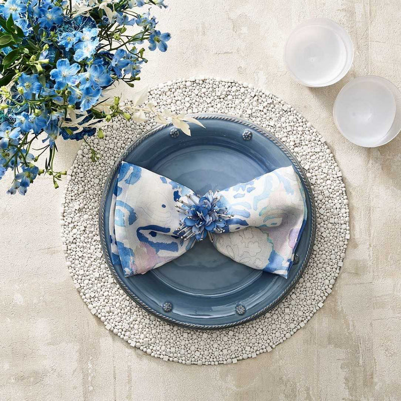 Styled watercolour napkin by Kim Seybert on white textured placemat, sold at Amiramour.