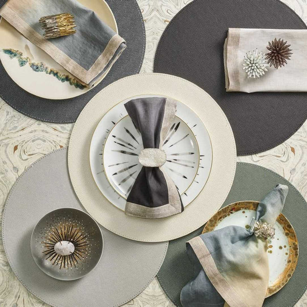 Grey and black ombre napkin styled with five different coloured placemats.