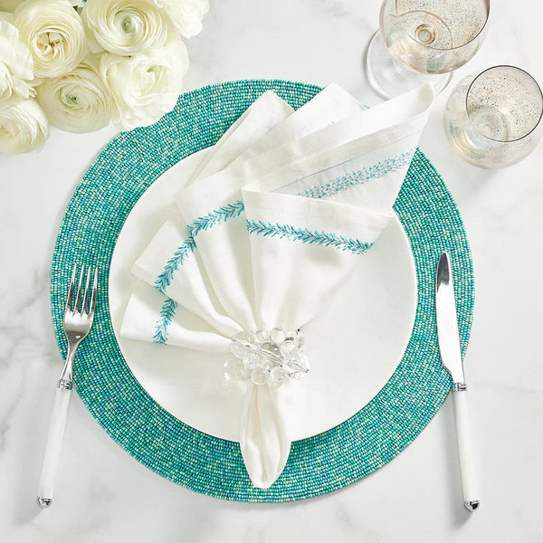 Top view of Jardin napkin on white and turquoise table setting, sold by Amiramour