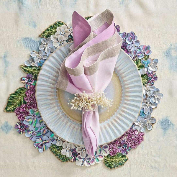 Lilac ombre linen napkin styled with spring tableware and floral placemat.