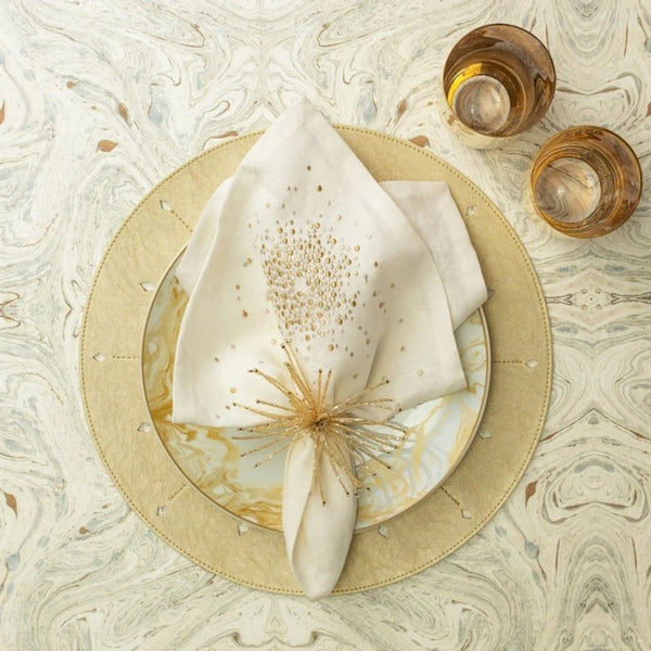 Luxurious cream and gold table setting featuring festive Spider Bead Burst Napkin Ring by Kim Seybert