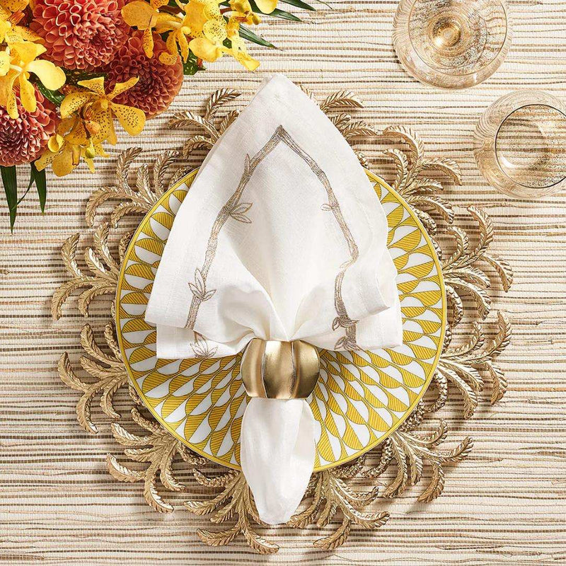 Tropical-themed gold table setup with Desert Napkin Ring by Kim Seybert