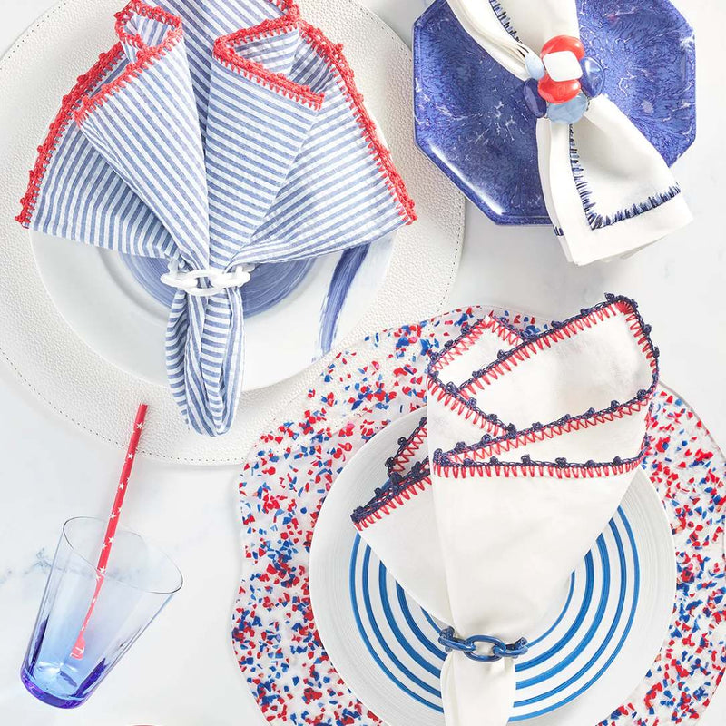 Multiple summer table arrangements in nautical colors, including navy enamel Chain Link Napkin Ring