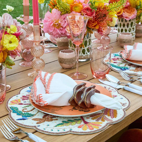 Colorful dining setup with close-up of Pavilion Napkin Ring in natural wood and gold