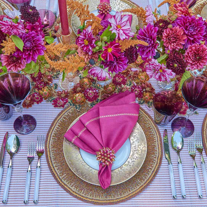 Floral table arrangement in plum shades featuring Zinnia Napkin Rings by Kim Seybert with abundant blooms and elegant tones