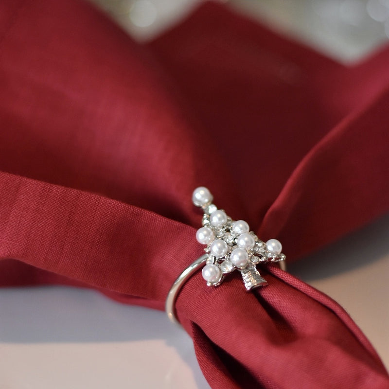 Christmas napkin ring by Goodwill with christmas tree motif, styled on red napkin. 