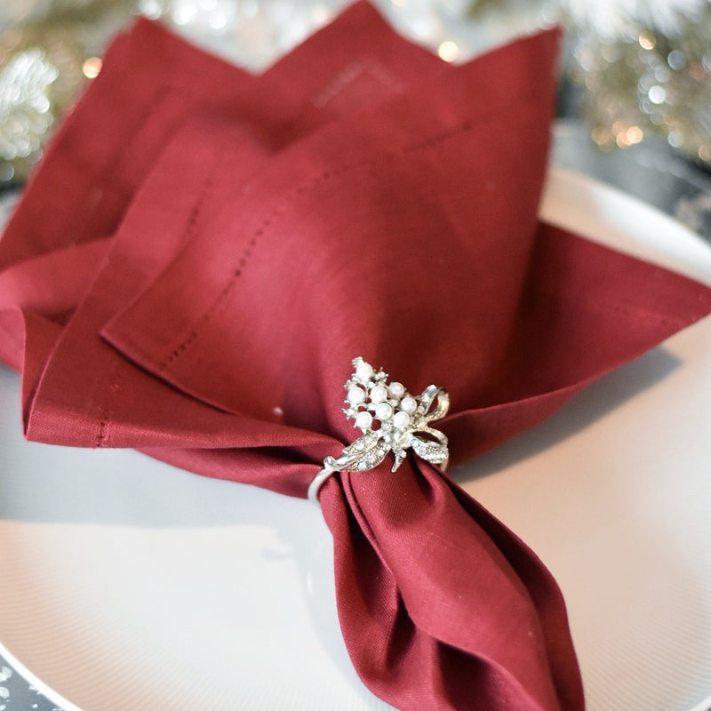Christmas napkin ring by Goodwill with mistletoe motif, styled on red napkin. 