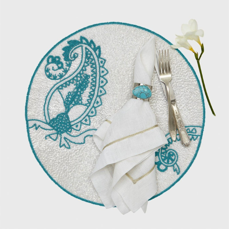 Overhead view of turquoise gilt edge shell napkin ring with coordinating summer décor