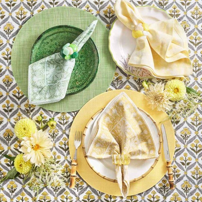 Three table settings in green and yellow tones, with green Sea Stone Napkin Ring in the green setting