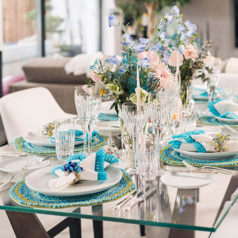 Partial view of turquoise and white summer table setup accented by Poppy Napkin Rings