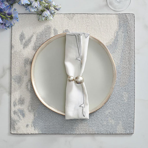 Pearl grey and silver Kim Seybert napkin ring styled on an elegant, luxury table setting.