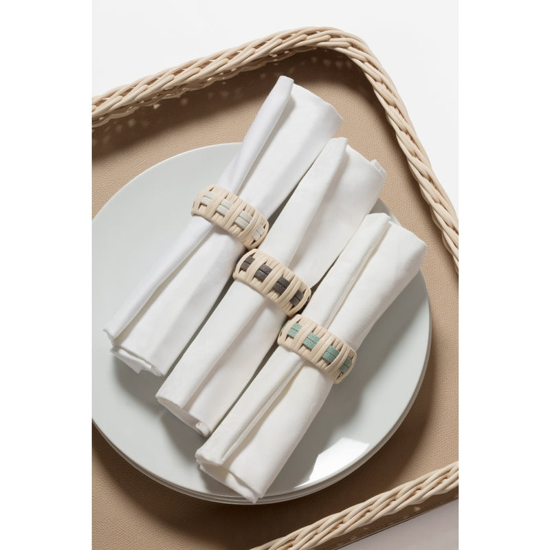 Anglet Napkin Rings in rattan with calfskin golf leather in Smoke G24, Mint G46, and Almond G116 on white napkins