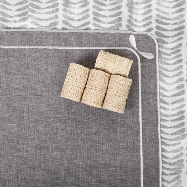 Beige oblong napkin rings on grey placemat by Roseberry Home