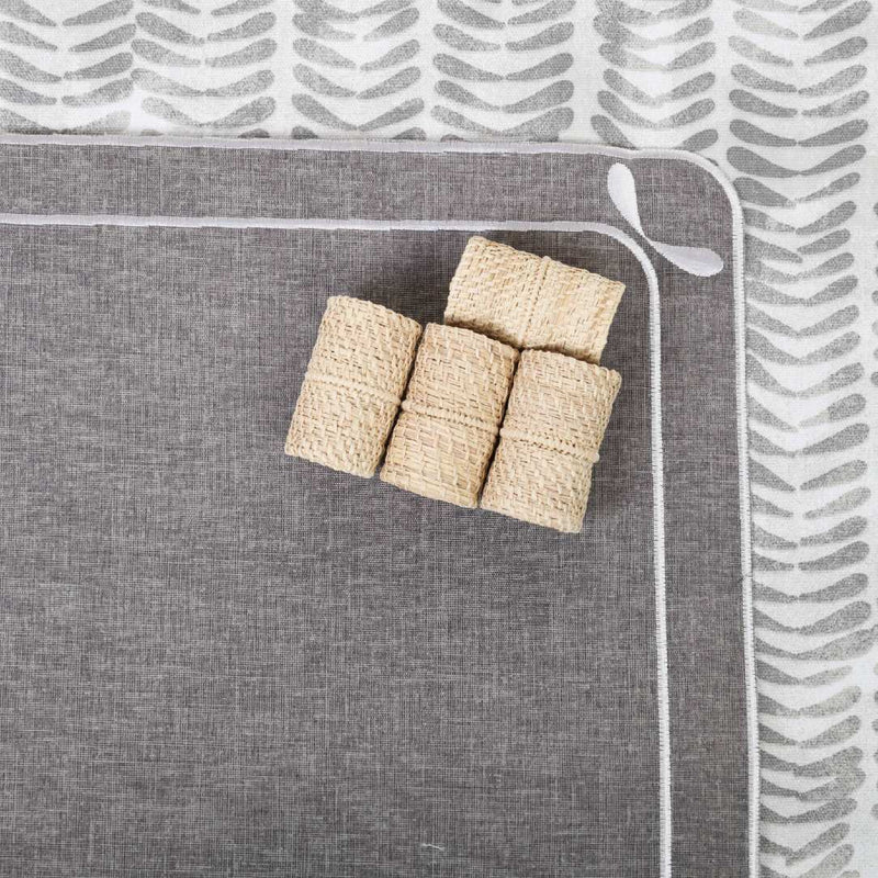 Beige oblong napkin rings on grey placemat by Roseberry Home