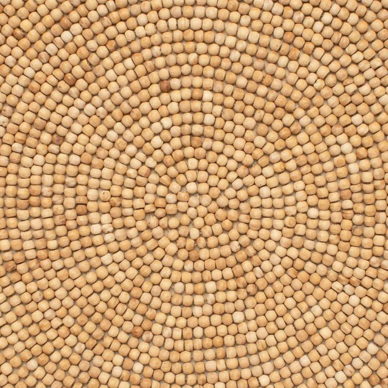 Natural wood bead round placemat by Kim Seybert close-up texture.