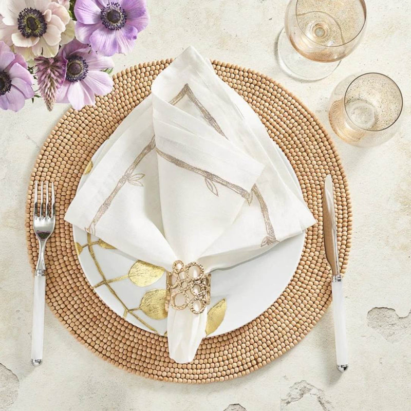 Natural wood bead round placemat by Kim Seybert styled with white napkin.