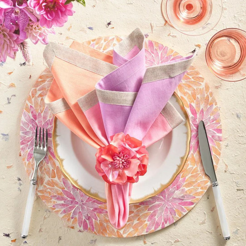 Pink and orange Capiz shell placemat in floral ombre design with orange napkin ring.