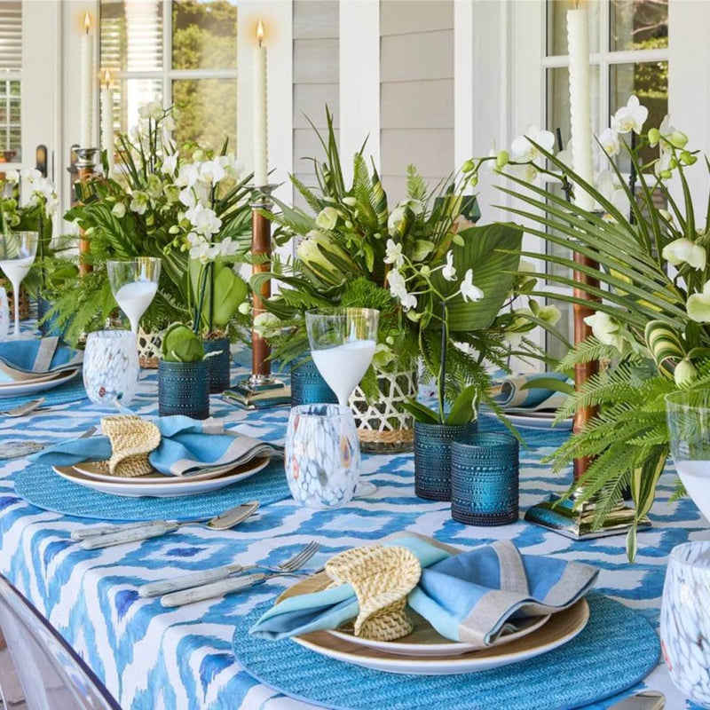 Indigo blue woven herringbone round placemat on luxury tropical table setting.