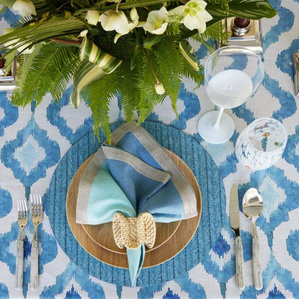 Indigo blue woven herringbone round placemat on tropical tablescape.