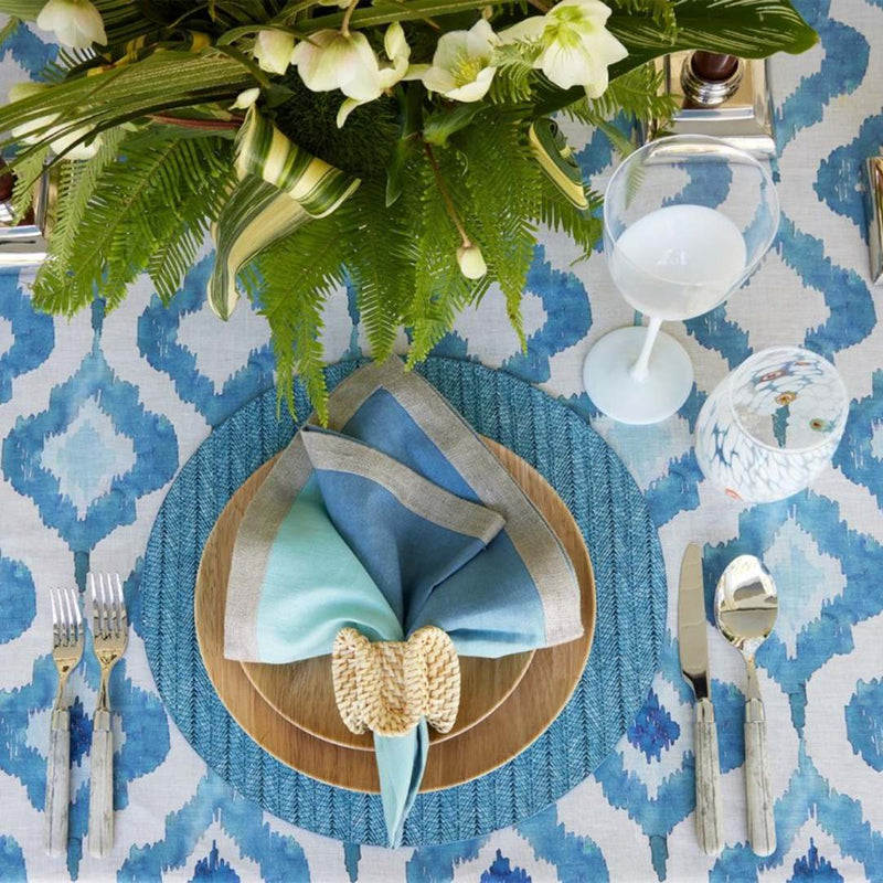 Indigo blue woven herringbone round placemat on tropical tablescape.