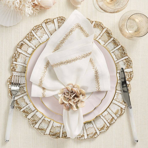 Nautilus placemat in white, gold, and champagne hand-beaded spiral design styled on white and gold tablescape.