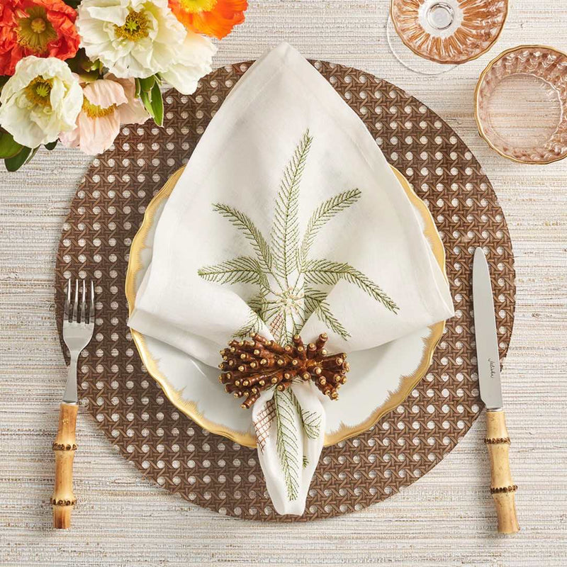 Reed placemat in brown faux wicker by Kim Seybert styled with palm tree napkin.